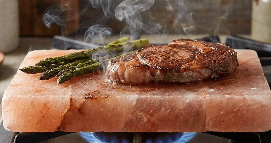Cooking on Salt Block Himalayan salt block on gas burner with steak and asparagus