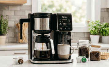 Best Dual Coffee Maker Review 2026: 5 Top 2-Way Machines A professional lifestyle photograph capturing a Ninja DualBrew Pro CM401 Dual Coffee Maker actively brewing a full carafe of coffee and a single K-Cup cup simultaneously on a modern kitchen counter