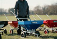 Best Fertilizer and Seed Spreaders for 2026: I Tested the Top Models (Real Results) A close-up photograph of three premium broadcast fertilizer and seed spreaders actively working in motion on a lush suburban lawn, representing the hands-on testing of top models for a 2026 article review on gardenfrontier.com.