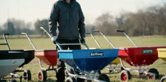 Best Fertilizer and Seed Spreaders for 2026: I Tested the Top Models (Real Results) A close-up photograph of three premium broadcast fertilizer and seed spreaders actively working in motion on a lush suburban lawn, representing the hands-on testing of top models for a 2026 article review on gardenfrontier.com.