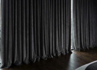 7 Best Soundproof Curtains (2026): Do They Actually Work? Thick, heavy-duty soundproof curtains installed over a large bedroom window to block street noise