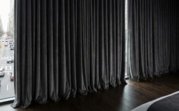 7 Best Soundproof Curtains (2026): Do They Actually Work? Thick, heavy-duty soundproof curtains installed over a large bedroom window to block street noise