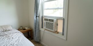 Cheap Window Air Conditioners Under $100 in 2026 Small cheap window air conditioner under $100 installed in a bedroom.