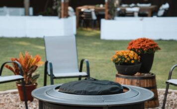 Solo Stove Surround Review 2026: Is The Protective Barrier Worth It? A burning Solo Stove fire pit placed securely inside the Surround protective barrier on a backyard patio at dusk. Two drinks and a bowl of snacks rest safely on the perforated metal tabletop, demonstrating the cool-to-touch safety feature.