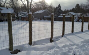 Frost Fence Cost 2026: How Much Does a Chain-Link Fence Really Cost? A newly installed frost fence with deep concrete footings in a snowy backyard.