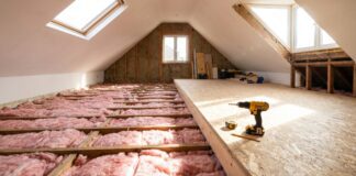 Attic Flooring 2026: Plywood vs OSB, Installation Guide & Exact Costs Installing OSB attic flooring over thick insulation using raised loft legs.