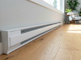 Baseboard Heater Covers 2026: DIY Upgrade A clean, modern white baseboard heater replacement cover installed along a freshly painted wall in a living room, showing the DIY transformation.