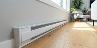 Baseboard Heater Covers 2026: DIY Upgrade A clean, modern white baseboard heater replacement cover installed along a freshly painted wall in a living room, showing the DIY transformation.
