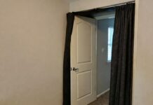 Door Soundproofing Guide 2026: Block Out Noise Fast A homeowner installing an automatic drop door sweep to block noise from entering a bedroom.