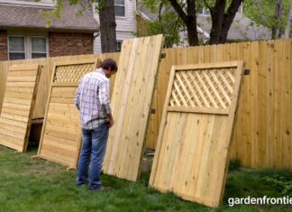 Fencing Types 2026: The Ultimate Guide to Backyard Fences A homeowner inspecting different wood fencing types in a residential backyard.
