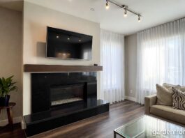 Granite Fireplaces (2026): Surrounds, Hearths & Design Ideas A modern living room featuring a sleek black granite fireplace surround and hearth.