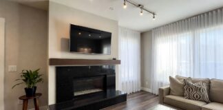 Granite Fireplaces (2026): Surrounds, Hearths & Design Ideas A modern living room featuring a sleek black granite fireplace surround and hearth.