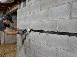 Horizontal Foundation Crack Repair: Costs & DIY Fixes A homeowner repairing a horizontal foundation crack in a basement wall using a carbon fiber strap and structural epoxy.