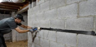 Horizontal Foundation Crack Repair: Costs & DIY Fixes A homeowner repairing a horizontal foundation crack in a basement wall using a carbon fiber strap and structural epoxy.