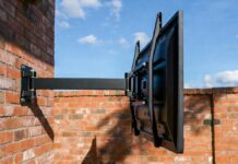 Best Outdoor TV Mounts (2026): Why Regular Mounts Rust and Fail A heavy-duty, rust-proof outdoor TV mount installed safely on a brick patio wall.