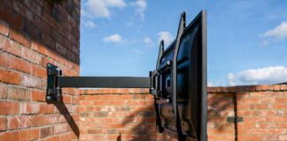 Best Outdoor TV Mounts (2026): Why Regular Mounts Rust and Fail A heavy-duty, rust-proof outdoor TV mount installed safely on a brick patio wall.