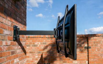 Best Outdoor TV Mounts (2026): Why Regular Mounts Rust and Fail A heavy-duty, rust-proof outdoor TV mount installed safely on a brick patio wall.