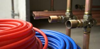 PEX vs Copper Repipe: 2026 Cost, Longevity & Pros/Cons A side-by-side comparison of flexible red and blue PEX tubing next to rigid copper plumbing pipes.