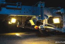 Best Magnetic Work Lights for Your Garage (2026 Reviews) A bright set of portable magnetic work lights stuck to the steel frame under a truck illuminating the suspension