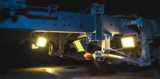 Best Magnetic Work Lights for Your Garage (2026 Reviews) A bright set of portable magnetic work lights stuck to the steel frame under a truck illuminating the suspension