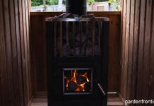 Wood Stove Sauna Heaters & Classic Wood Stoves (2026 Guide) A glowing wood stove sauna heater filled with hot stones in a cedar backyard sauna.