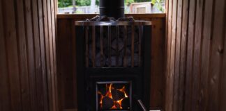 Wood Stove Sauna Heaters & Classic Wood Stoves (2026 Guide) A glowing wood stove sauna heater filled with hot stones in a cedar backyard sauna.