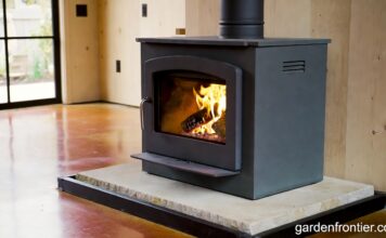 Soapstone Heaters (2026): Stoves, Panels & Masonry Guide A freestanding soapstone wood stove radiating heat in a modern farmhouse living room.
