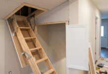 Attic Door Installation: Cost, Steps & When to Hire a Pro A contractor installing a ceiling attic access door with a framed opening and pull-down attic ladder