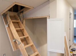 Attic Door Installation: Cost, Steps & When to Hire a Pro A contractor installing a ceiling attic access door with a framed opening and pull-down attic ladder