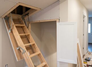 Attic Door Installation: Cost, Steps & When to Hire a Pro A contractor installing a ceiling attic access door with a framed opening and pull-down attic ladder
