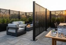 Best Outdoor Privacy Screens for Wind: Metal, Freestanding & Heavy-Duty Picks Heavy-duty black metal outdoor privacy screen anchored on a windy patio with plants and seating