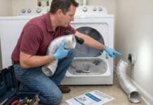 Dryer Taking Too Long to Dry? 9 Vent, Lint & Airflow Problems to Check Homeowner checking a dryer vent hose and lint buildup behind a clothes dryer in a laundry room