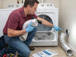 Dryer Taking Too Long to Dry? 9 Vent, Lint & Airflow Problems to Check Homeowner checking a dryer vent hose and lint buildup behind a clothes dryer in a laundry room