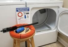 Dryer Vent Cleaning Brush Guide: Best Kits, How to Use One & Safety Mistakes Dryer vent cleaning brush kit with flexible rods vacuum attachment and lint brush beside a laundry dryer