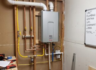 Gas Tankless Water Heater Installation Cost: Venting, Gas Lines & Sizing A gas tankless water heater installed on a utility room wall with venting and gas line connections