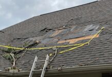 Missing Shingles on Roof: Will It Leak, Can You Replace Them, or Is It Time for a New Roof? A roof with several missing asphalt shingles after wind damage exposing the underlayment