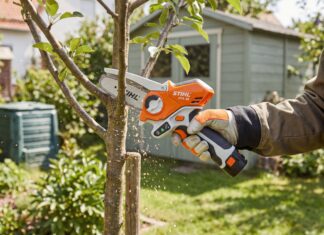 Stihl Mini Chainsaw Guide: GTA 26, Battery Options & What to Know Before Buying A compact Stihl mini chainsaw style pruning saw cutting a small tree branch in a backyard