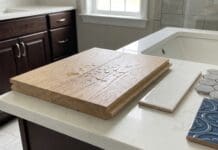Engineered Hardwood Flooring in Bathrooms: Smart or Risky? Engineered hardwood flooring sample near a bathroom vanity with water droplets and tile samples