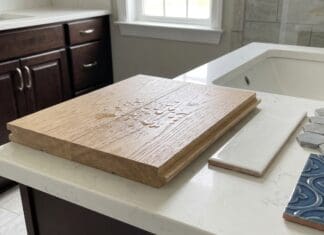 Engineered Hardwood Flooring in Bathrooms: Smart or Risky? Engineered hardwood flooring sample near a bathroom vanity with water droplets and tile samples