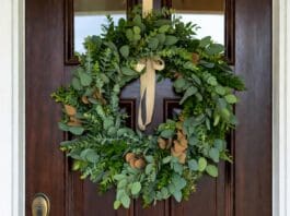 Eucalyptus Wreath: Fresh, Faux, Dried & DIY Ideas Fresh eucalyptus wreath hanging on a front door with natural green leaves and simple ribbon