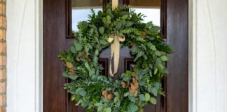 Eucalyptus Wreath: Fresh, Faux, Dried & DIY Ideas Fresh eucalyptus wreath hanging on a front door with natural green leaves and simple ribbon