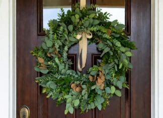Eucalyptus Wreath: Fresh, Faux, Dried & DIY Ideas Fresh eucalyptus wreath hanging on a front door with natural green leaves and simple ribbon