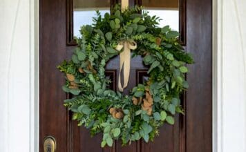 Eucalyptus Wreath: Fresh, Faux, Dried & DIY Ideas Fresh eucalyptus wreath hanging on a front door with natural green leaves and simple ribbon