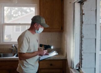 Exterminator Prices: Average Pest Control Costs by Pest Type Pest control technician inspecting a residential kitchen and exterior wall for common household pests