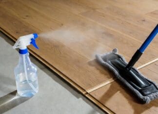 How to Clean Engineered Hardwood Floors Without Damage Microfiber mop cleaning engineered hardwood flooring with a light spray cleaner and no standing water