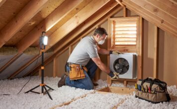 Attic Fan Installation: Cost, Types, Pros, Cons & When It’s Worth It Contractor installing an attic fan near a roof vent in a residential attic