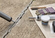 Best Concrete Crack Filler for Driveways, Patios & Large Cracks Concrete crack filler applied to a driveway crack with repair tools nearby
