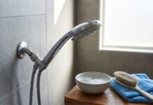 How to Clean a Shower Head and Restore Water Pressure Fast Cleaning a chrome shower head with mineral buildup in a modern bathroom
