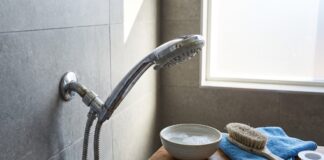How to Clean a Shower Head and Restore Water Pressure Fast Cleaning a chrome shower head with mineral buildup in a modern bathroom