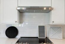 Range Hood Charcoal Filters: How Often to Replace Them & What to Buy Range hood charcoal filters and metal grease filter on a kitchen counter below a ductless hood